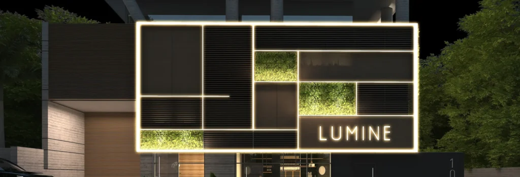 Letreiro iluminado do Lumine sobre painel de madeira e vegetação, à noite